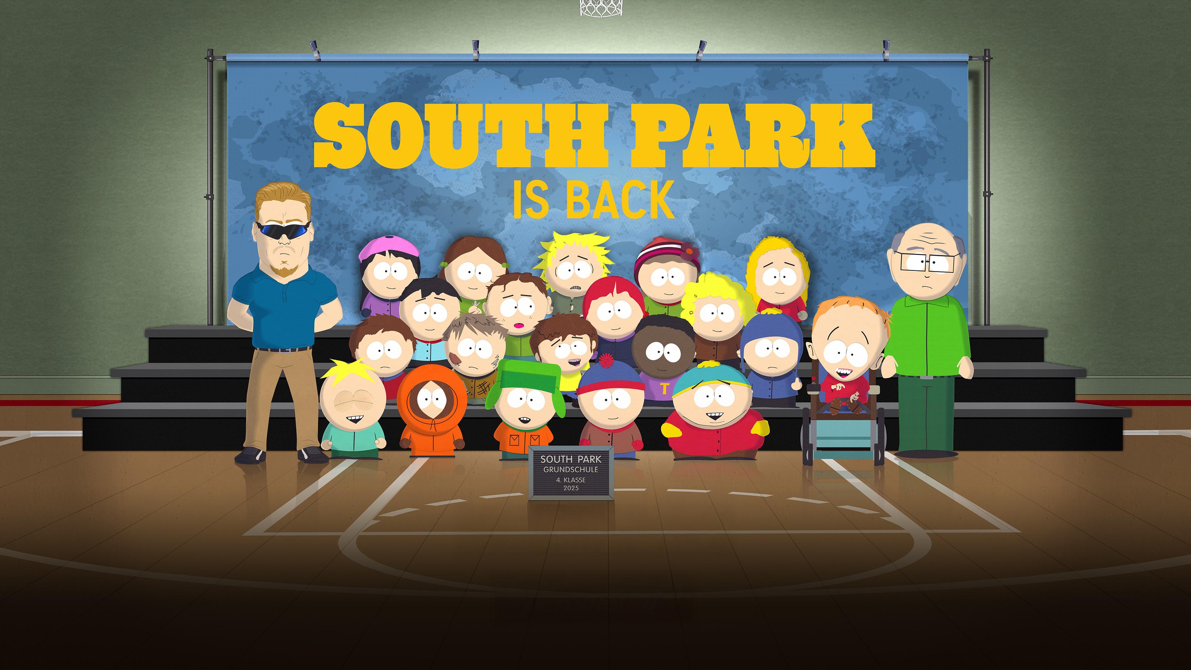 Comic-Zeichnung: Eine Schulklasse mit zwei Lehrern hat sich zu einem Klassenfoto vor einer blauen Tafel versammelt, auf der South Park is back steht.