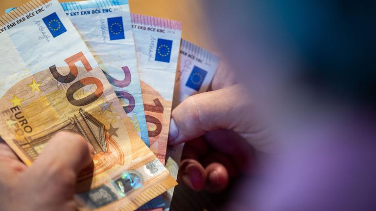 Symbolbild: Ein älterer Mann zählt Geld an einem Tisch.