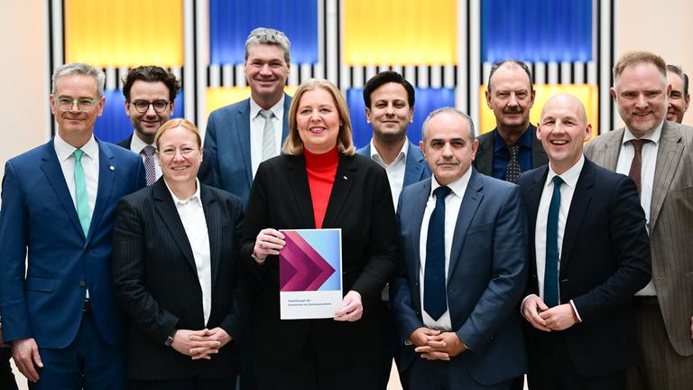 Berlin: Bärbel Bas (SPD), Bundesministerin für Arbeit und Soziales, steht während der Übergabe des Berichts der Kommission zur Sozialstaatsreform mit den Kommissionsmitgliedern im Arbeitsministerium.