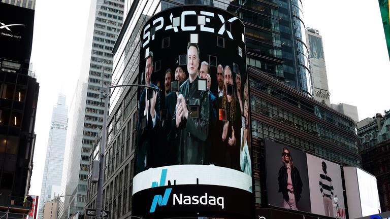 Bildschirme am Times Square, die Bilder von Elon Musk und dem SpaceX-Branding an der Nasdaq MarketSite Exchange zeigen