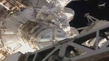 Spacewalk einer Astronautin die eine Antenne an der ISS repariert.