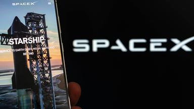 Symbolbild: SpaceX-Logo und Starship auf dem Smartphone-Bildschirm.