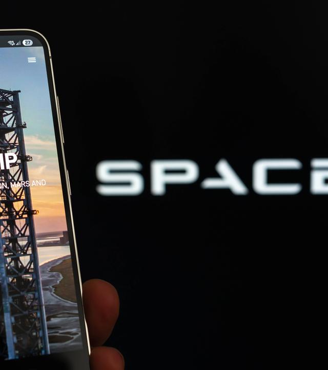Symbolbild: SpaceX-Logo und Starship auf dem Smartphone-Bildschirm.