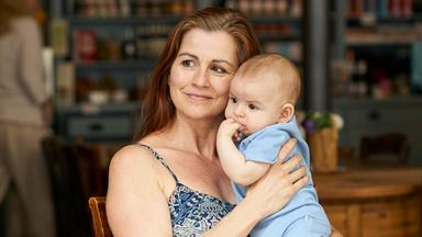 Nadine hält ihr Baby auf dem Arm.