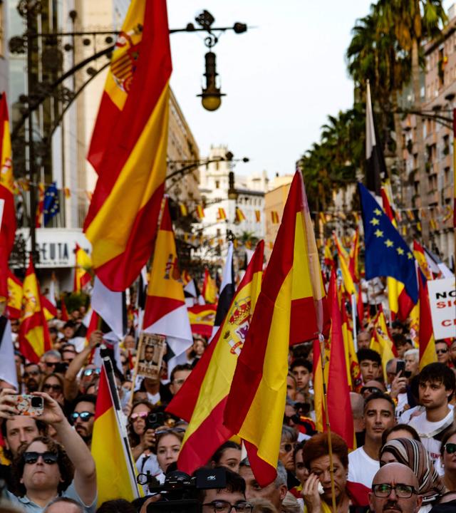 Demonstranten halten spanische Flaggen und Schilder während einer Demo gegen die Migrationskrise in Ceuta