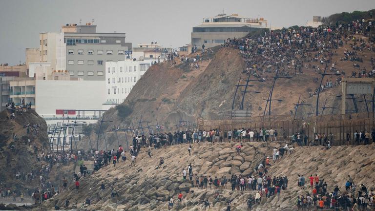 Migranten kehren nach Marokko zurück, nachdem sie die Grenze zur spanischen Exklave Ceuta in Nordafrika überquert hatten.