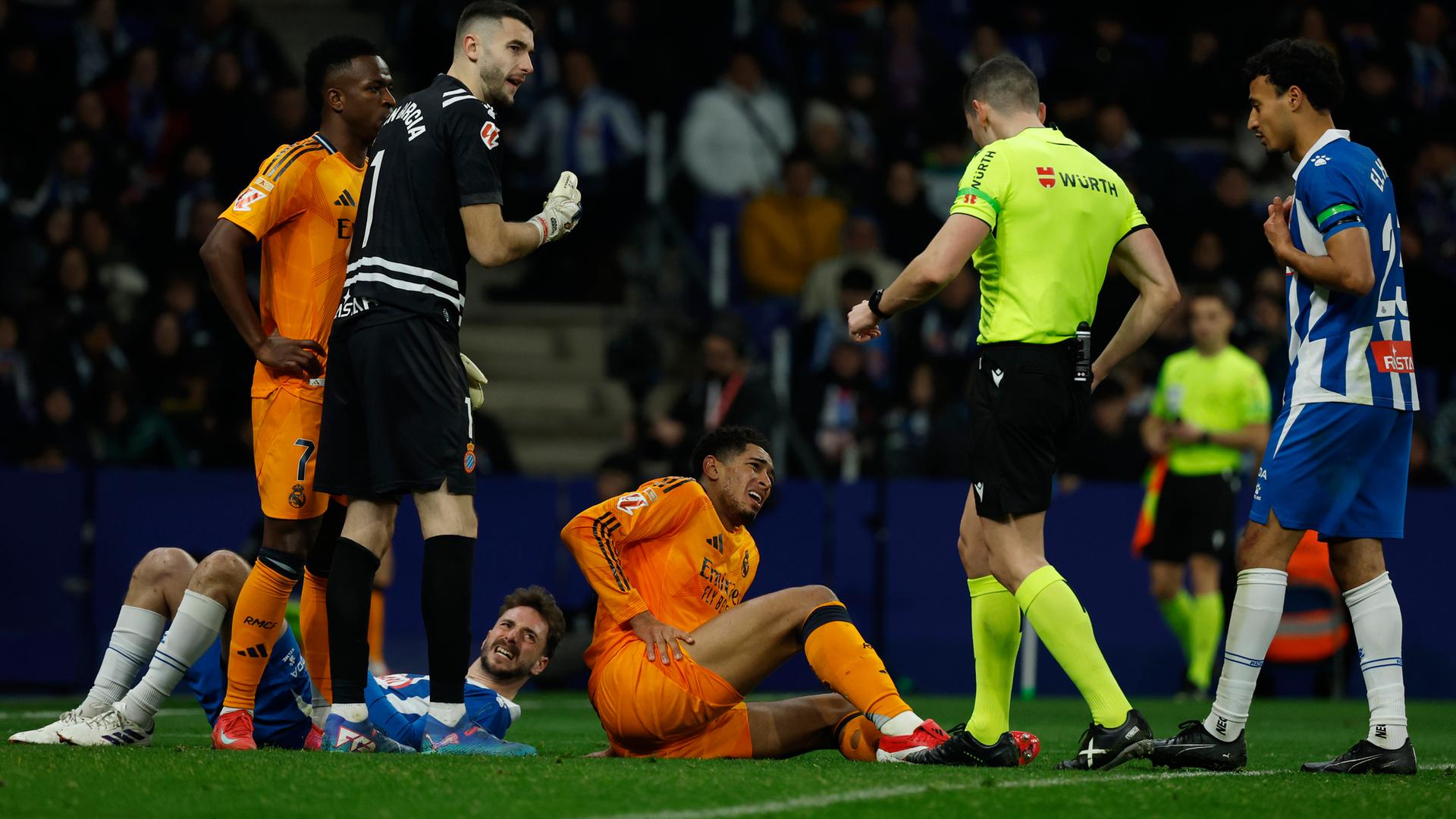 Jude Bellingham von Real Madrid hält sein Bein, während er in einem Fußballspiel der spanischen La Liga zwischen Espanyol und Real Madrid im Olympiastadion Lluis Companys in Barcelona auf dem Boden liegt.
