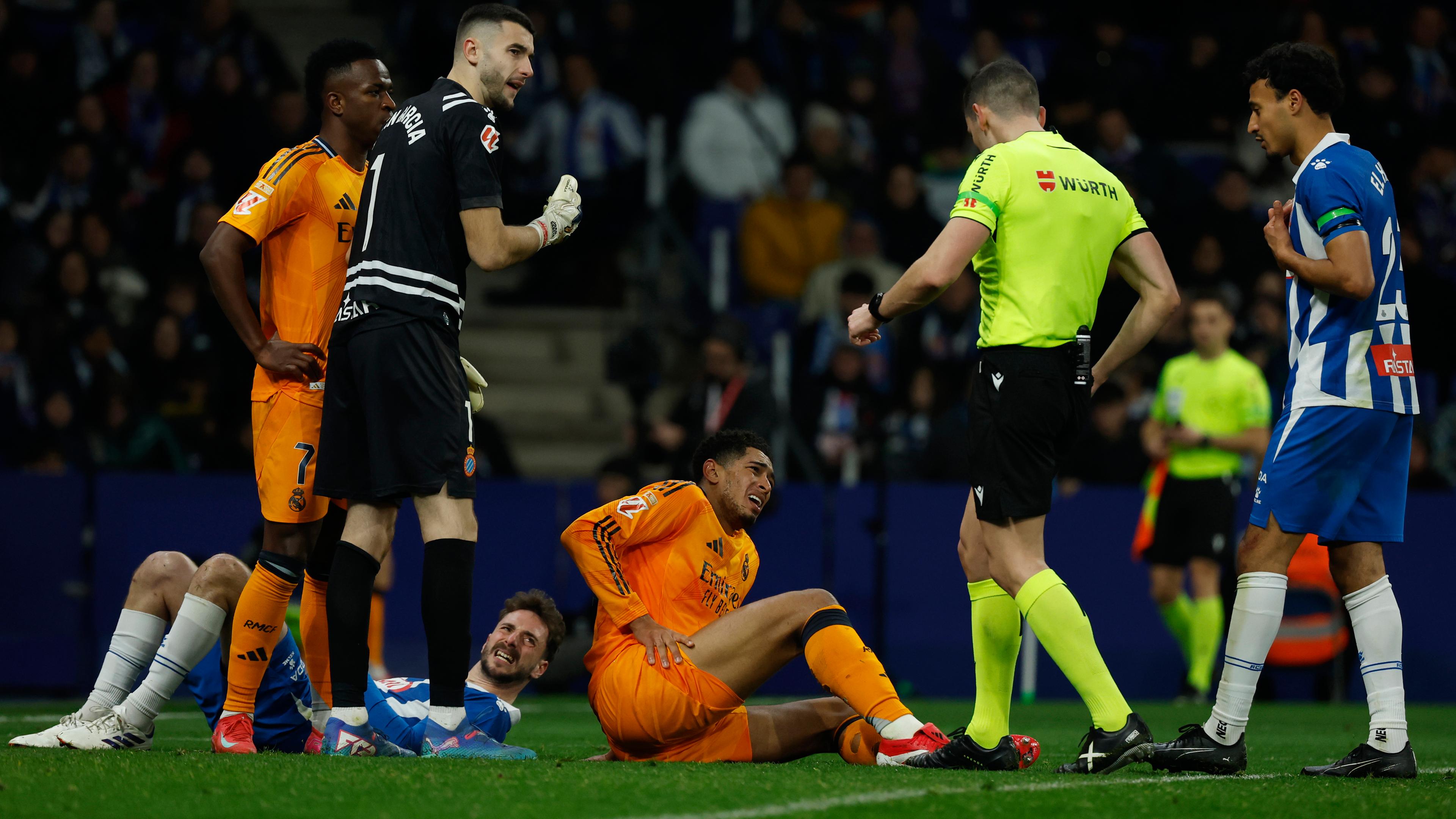 Jude Bellingham von Real Madrid hält sein Bein, während er in einem Fußballspiel der spanischen La Liga zwischen Espanyol und Real Madrid im Olympiastadion Lluis Companys in Barcelona auf dem Boden liegt.