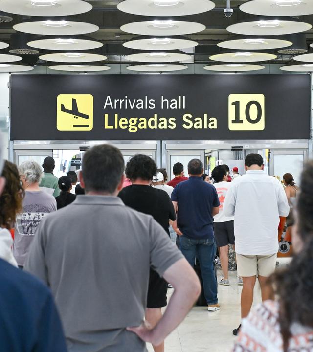 Im Ankunftsbereich des Terminals 4 am Flughafen Madrid-Barajas Adolfo Suárez sind mehrere Personen zu sehen