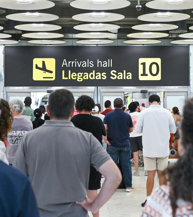 Im Ankunftsbereich des Terminals 4 am Flughafen Madrid-Barajas Adolfo Suárez sind mehrere Personen zu sehen