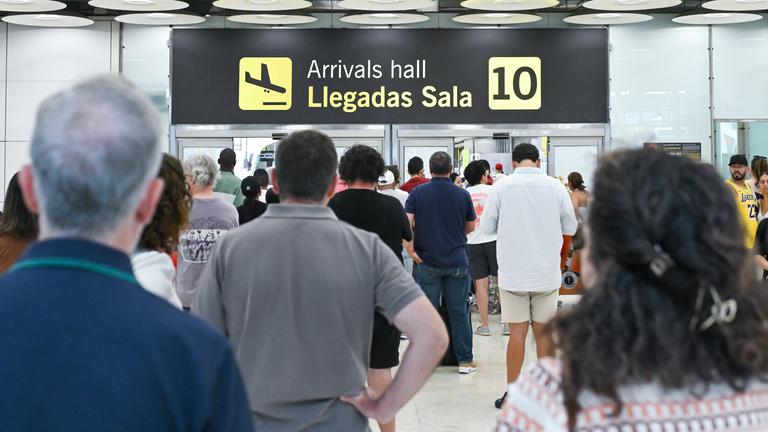 Im Ankunftsbereich des Terminals 4 am Flughafen Madrid-Barajas Adolfo Suárez sind mehrere Personen zu sehen