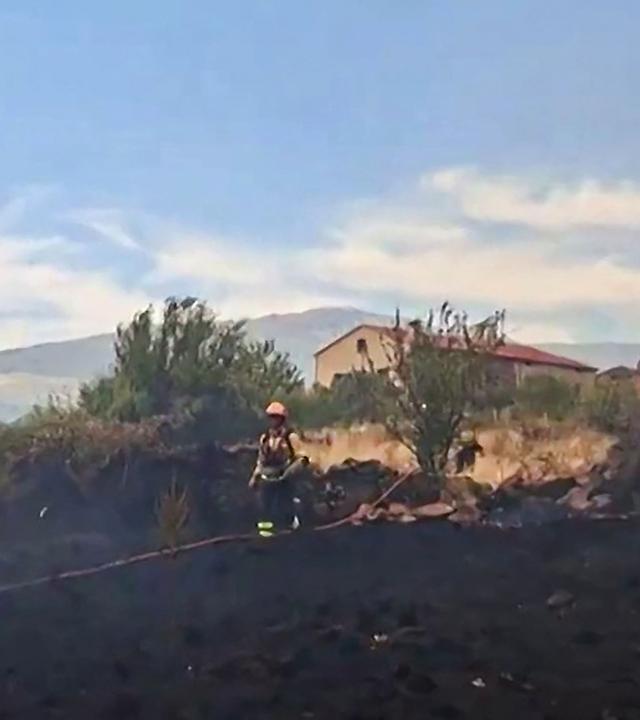 Feuerwehrleute bekämpfen einen Waldbrand in der Nähe von Wohnhäusern im Gebiet La Mierla, in der Nähe von Guadalajara, etwa 100 Kilometer nördlich von Madrid.