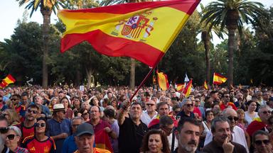 Menschen demonstrieren in Spanien mit Flaggen.