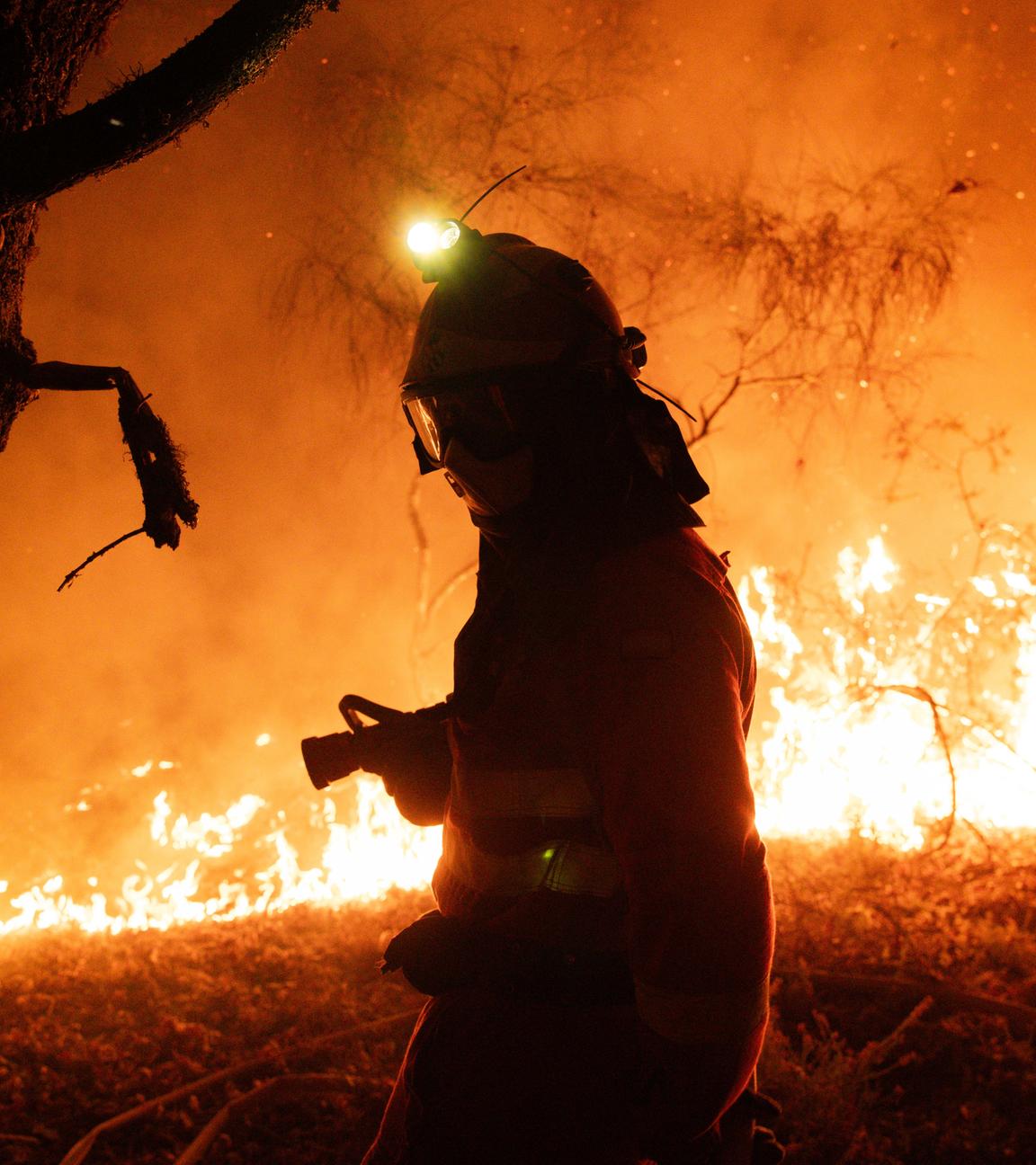 A handout photo made available by the Spanish Minister of Defense shows a firefighter working to extinguish a forest fire in Oimbra, Ourense, Galicia, Spain, 19 August 2025.