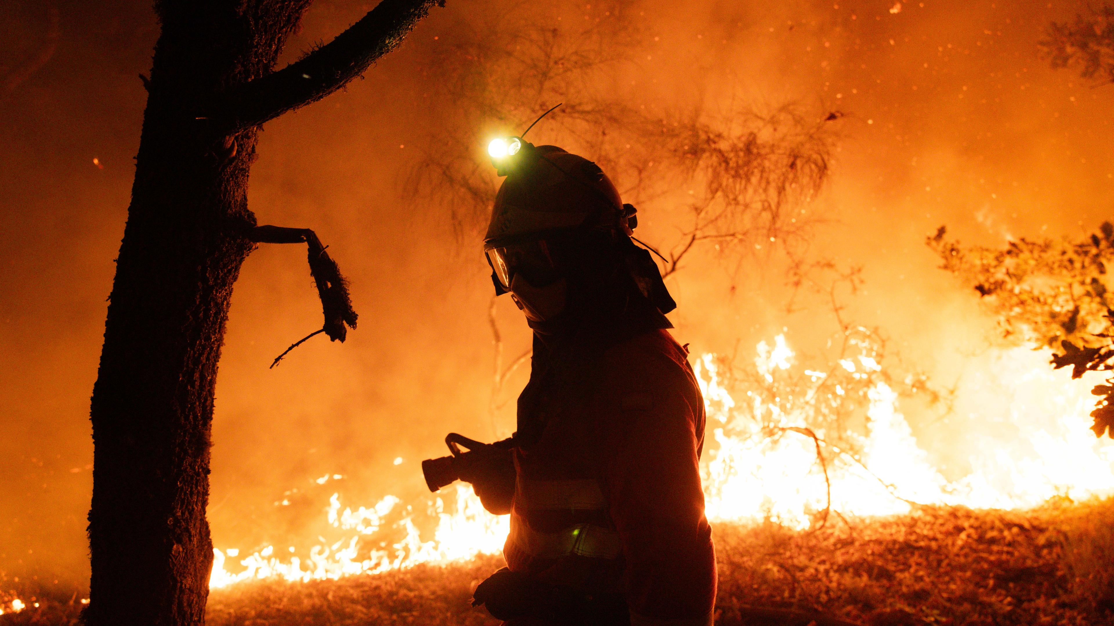 A handout photo made available by the Spanish Minister of Defense shows a firefighter working to extinguish a forest fire in Oimbra, Ourense, Galicia, Spain, 19 August 2025.