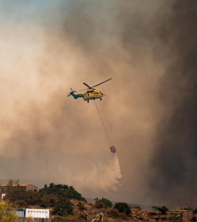 10.07.2026, Spanien, Los Gallardos (Almeria): Ein Löschhubschrauber wirft über dem Waldbrand Wasser ab.