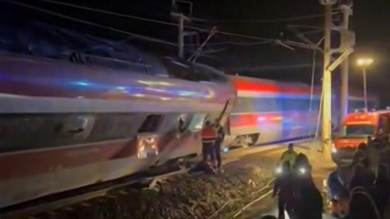 Man sieht dunkle Schienen und Sicherheitspersonal