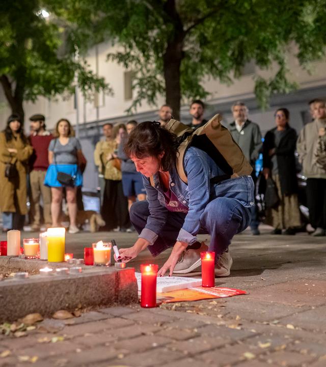07.10.2026, Spanien, Madrid: Menschen stellen vor dem Haus, in dem Maricarmen Abascal in Madrid wohnte, Kerzen auf.