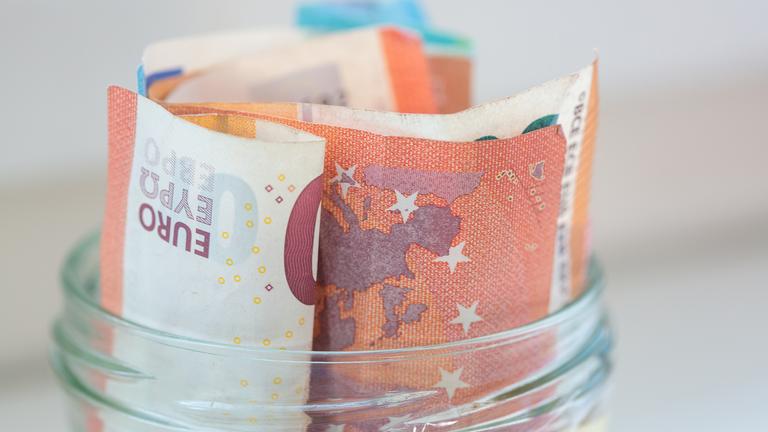 In einem Einmachglas stecken mehrere zusammengerollte Euro-Scheine.