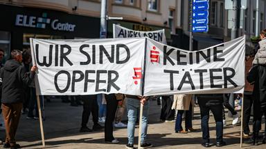 Teilnehmer einer Protestkundgebung demonstrieren gegen das als intransparent empfundene Verhalten der Sparkasse Gelsenkirchen.