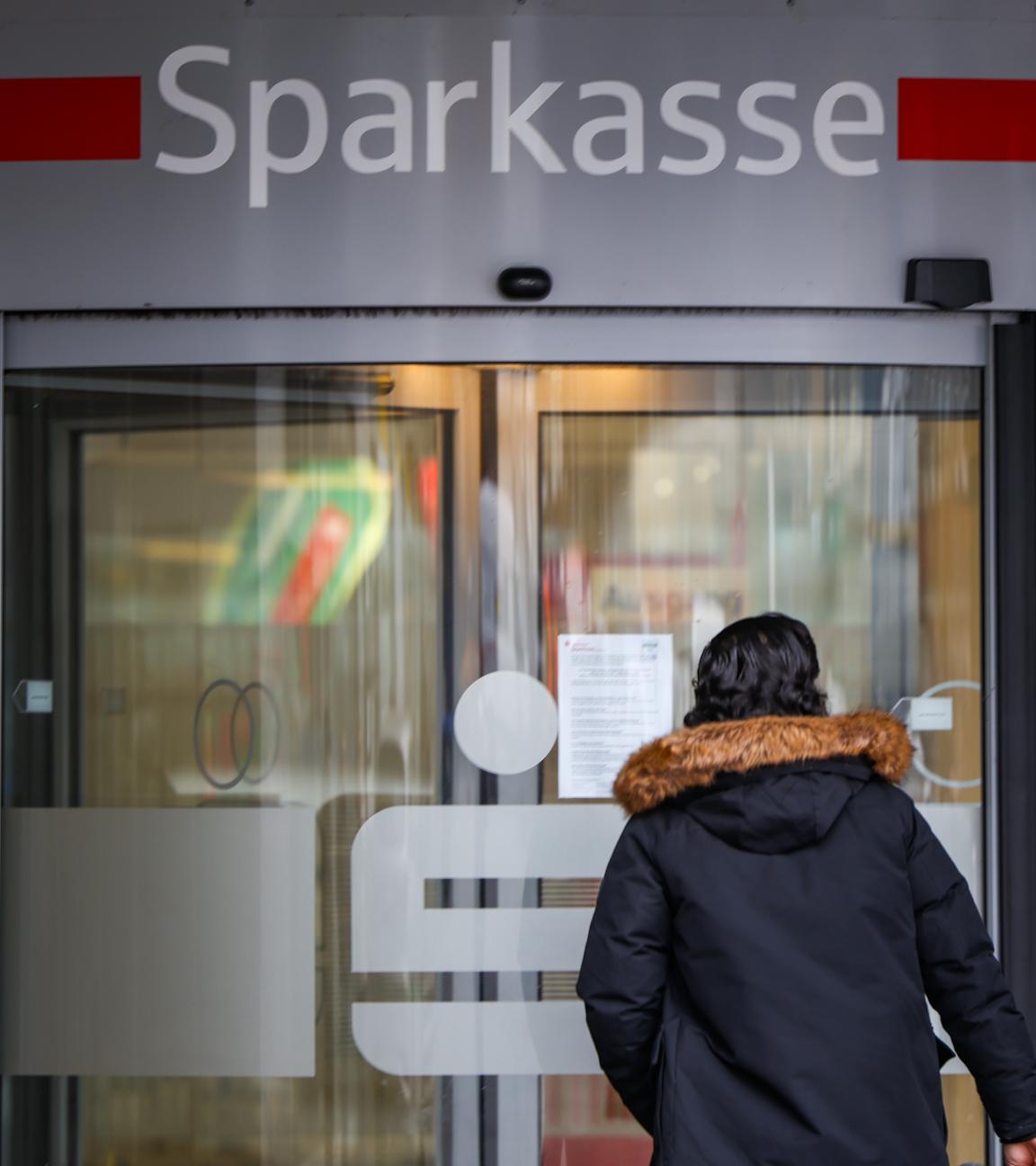 Ein Mann steht vor der Sparkassenfiliale Gelsenkirchen-Buer, die nach einem Einbruch weiterhin geschlossen ist. 