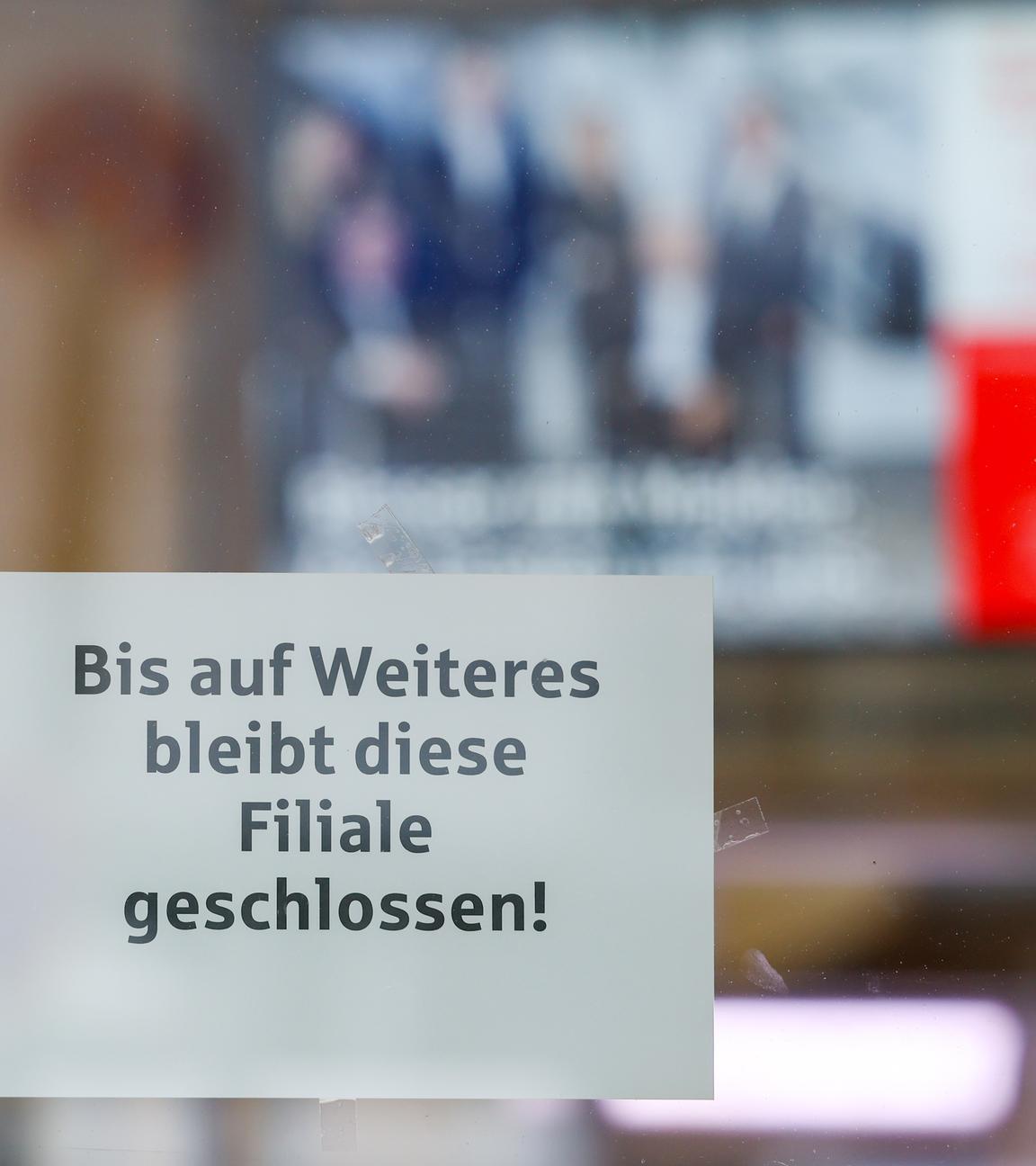 Nordrhein-Westfalen, Gelsenkirchen: Ein Hinweiszettel zur weiterhin bestehenden Schließung hängt an der Glasscheibe des Vorraums der Sparkassenfiliale, im Inneren ein Monitor mit dem Sparkassen-Logo.
