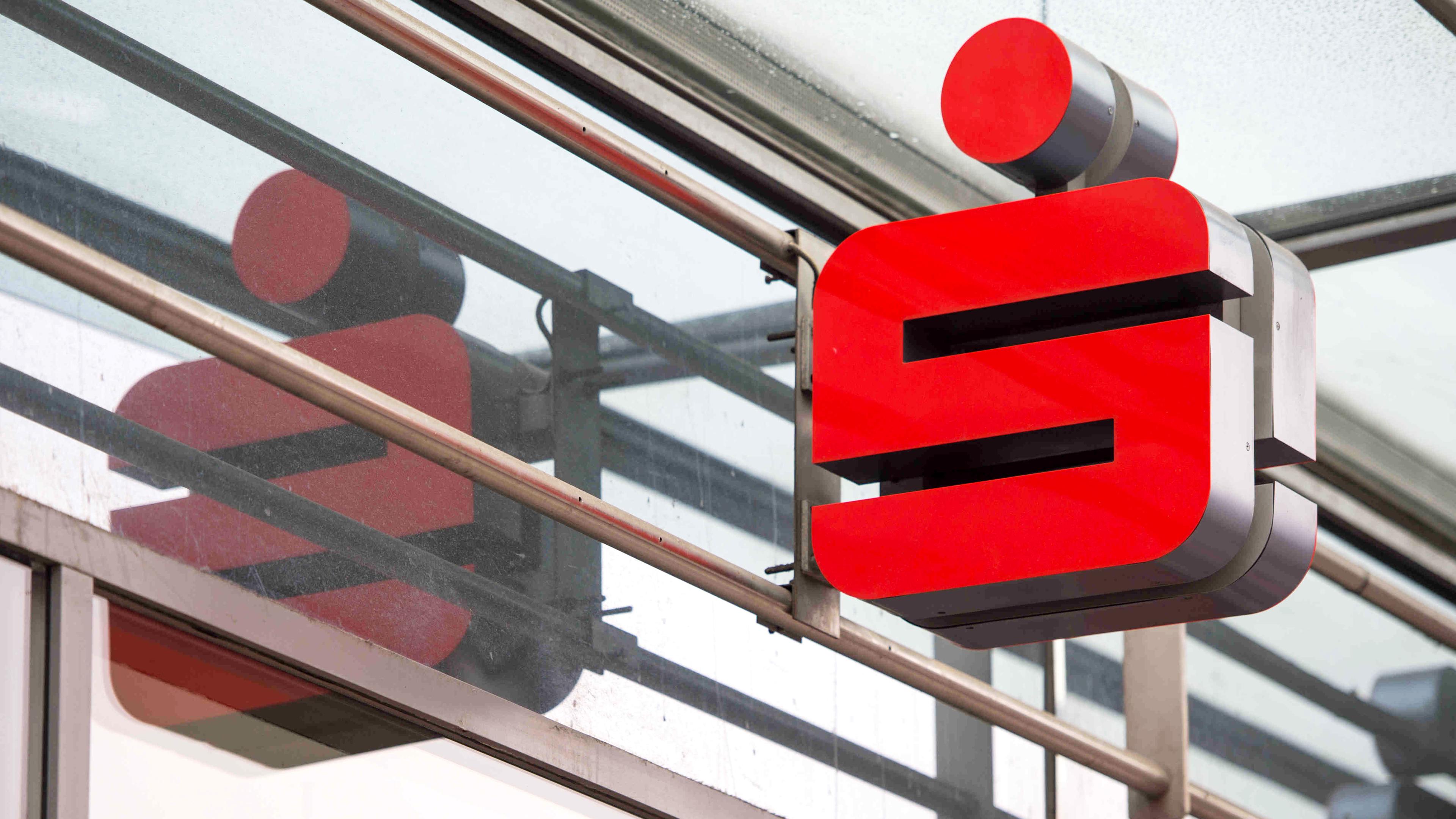 Berlin: Ein Sparkassenlogo hängt an der Fassade einer Berliner Sparkassen-Filiale. 