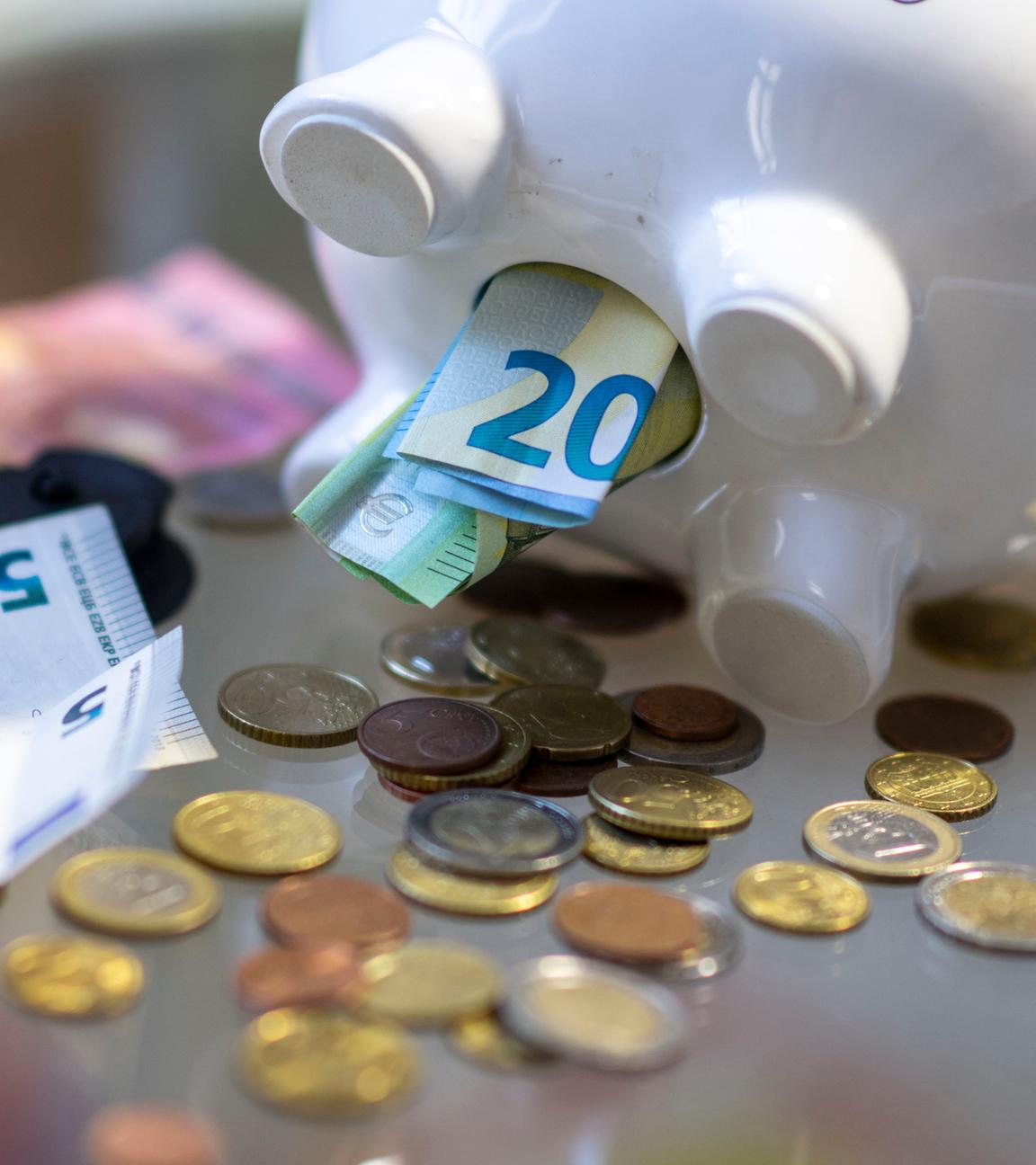 Sachsen, Leipzig: Geld steckt im Bauch eines Sparschweins.