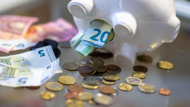 Sachsen, Leipzig: Geld steckt im Bauch eines Sparschweins.