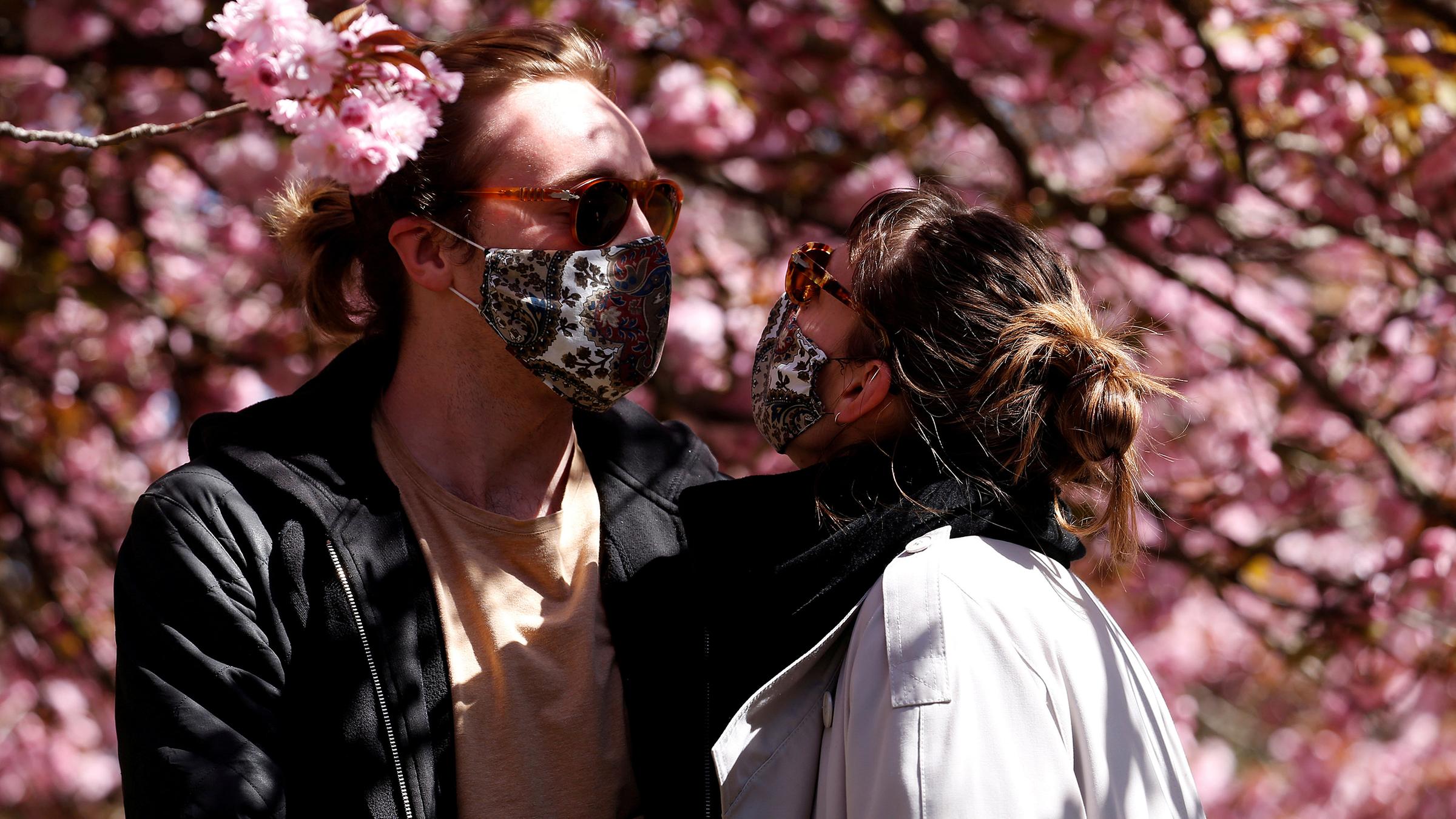 Archiv: Späziergänger mit Schutzmasken im Treptow Park in Berlin.