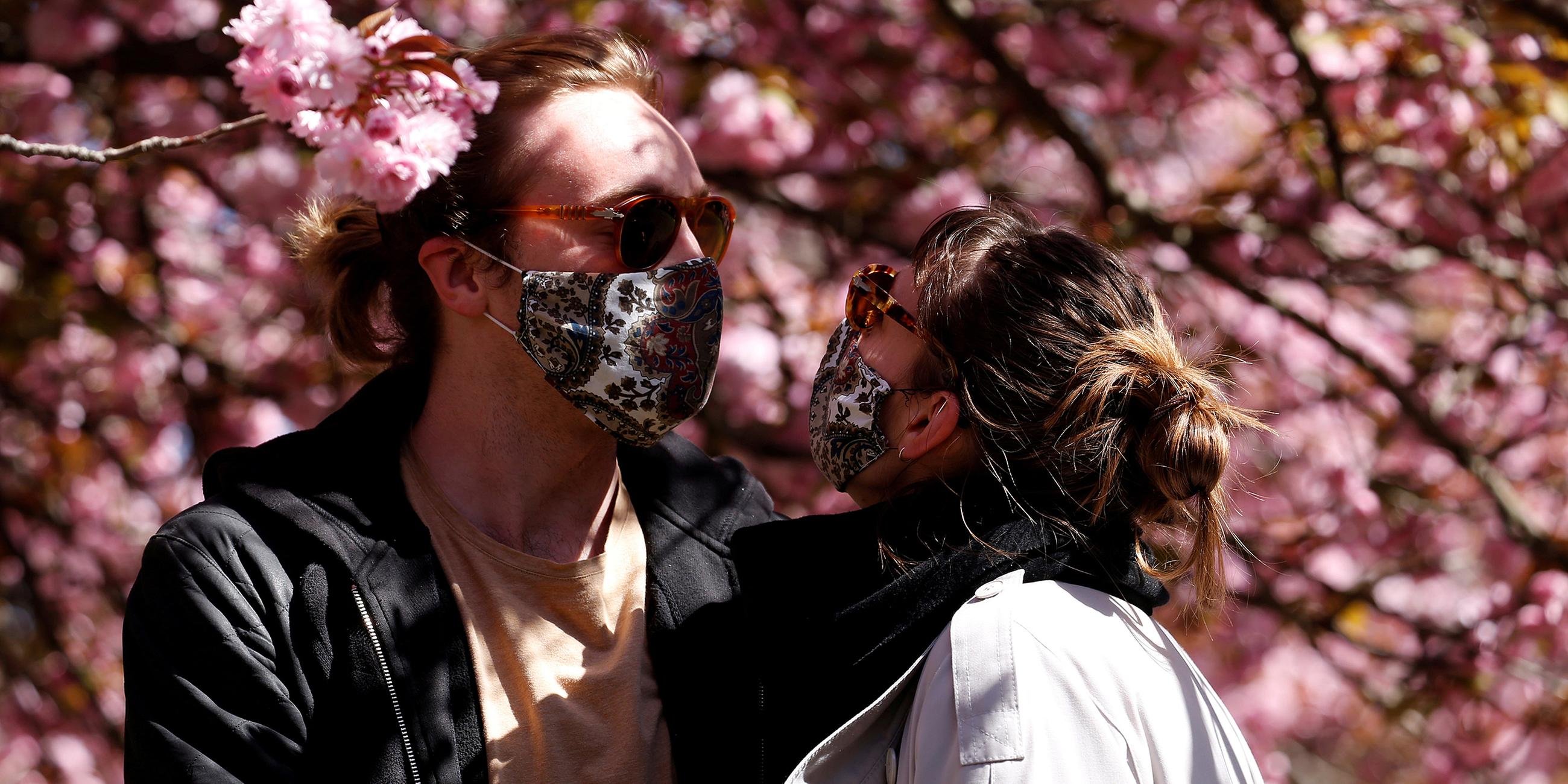 Archiv: Späziergänger mit Schutzmasken im Treptow Park in Berlin.