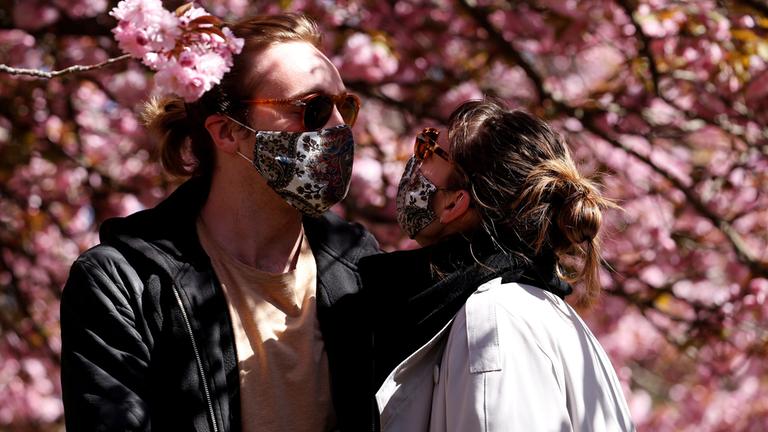 Archiv: Späziergänger mit Schutzmasken im Treptow Park in Berlin.