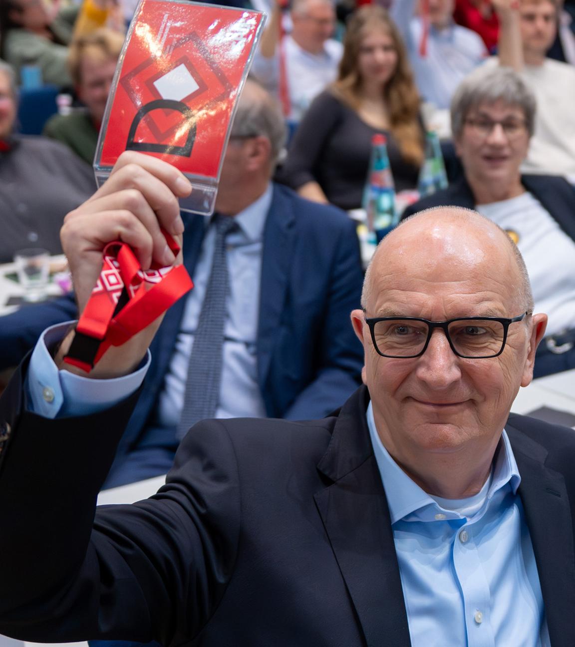 Dietmar Woidke (l, SPD), Ministerpräsident von Brandenburg, und Kurt Fischer (r), Generalsekretär der SPD-Brandenburg, halten während des Brandenburger SPD-Landesparteitages bei der Abstimmung über den Koalitionsvertrag zwischen SPD und CDU die roten Stimmkarten hoch.
