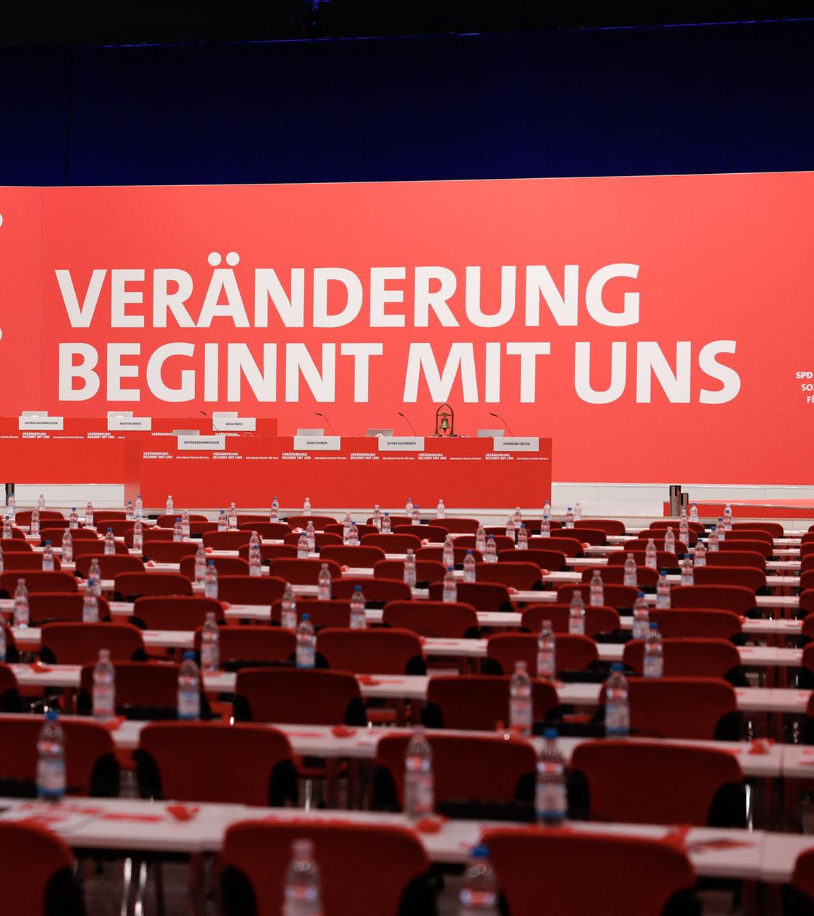 Die Halle, in der der SPD-Parteitag stattfindet. Reihen roter Stühle stehen vor einer Bühne. Auf deren Wand ist zu lesen: Veränderung beginnt mit uns. 