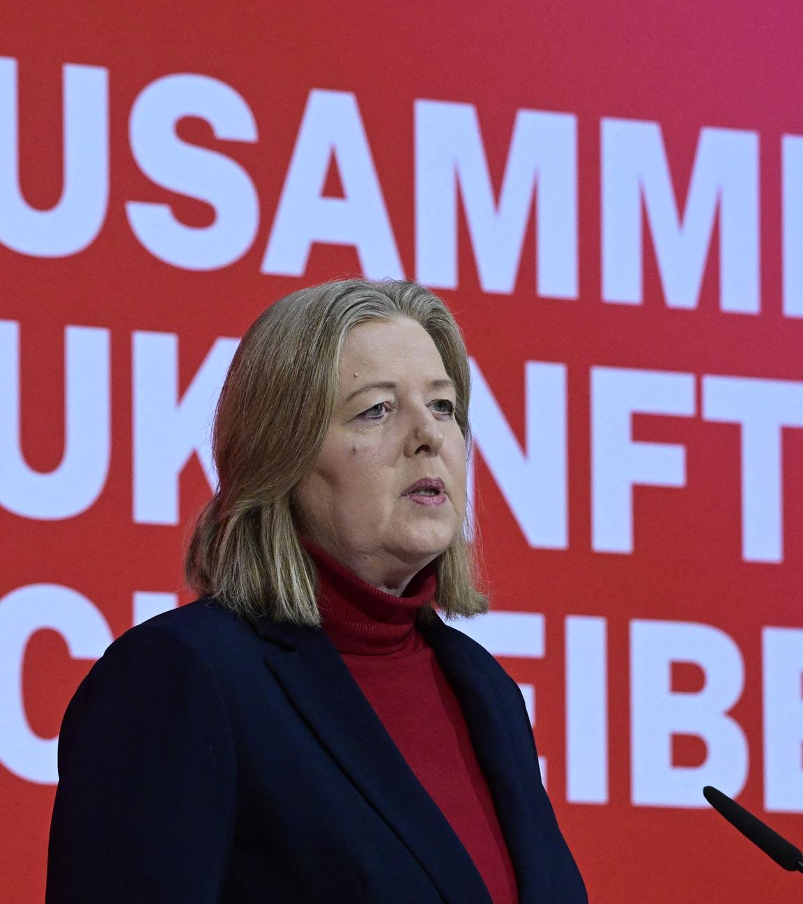 Bärbel Bas spricht zu den Anwesenden der Jahresauftaktsversammlung der SPD. Sie steht vor einem roten Hintergrund auf dem die Worte "Zusammen Zukunft schreiben" stehen.