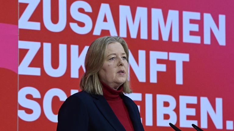 Bärbel Bas spricht zu den Anwesenden der Jahresauftaktsversammlung der SPD. Sie steht vor einem roten Hintergrund auf dem die Worte "Zusammen Zukunft schreiben" stehen.