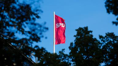 Die Fahne der Sozialdemokratischen Partei, SPD weht im Wind auf dem Dach der Parteizentrale in Berlin.