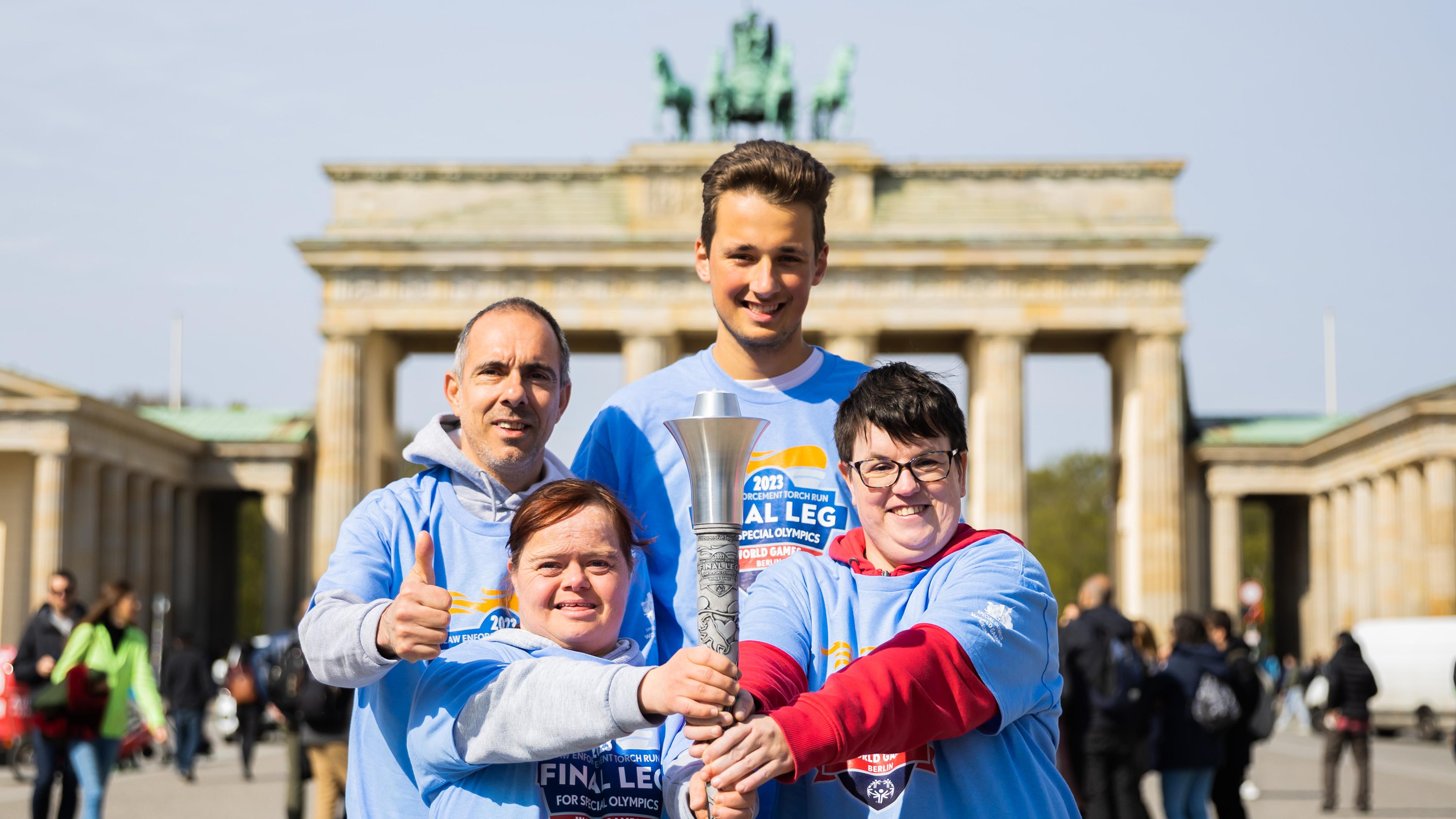 Nicole Pietschmann (vorne l-r), Schwimmerin, Juliana Rößler, Kanutin und Athletenspecherin, Marko Fähling (hinten l-r), Leichtathlet, und Louis Kleemeyer, Tennisspieler und Mitglied des Organisationskomitees, halten die Fackel für die Special Olympics World Games, als diese am Brandenburger Tor vorgestellt wird. 