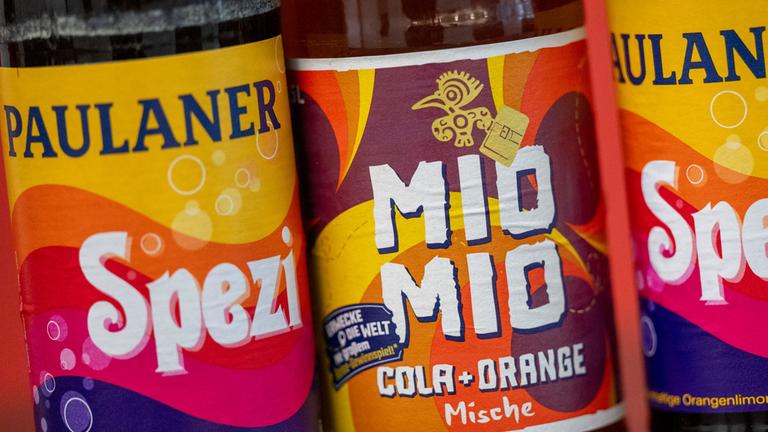  Zwei Spezi-Flaschen des Herstellers Paulaner stehen neben einer Flasche Mio-Mio-Cola-Orange-Mische (M) des Herstellers Berentzen.