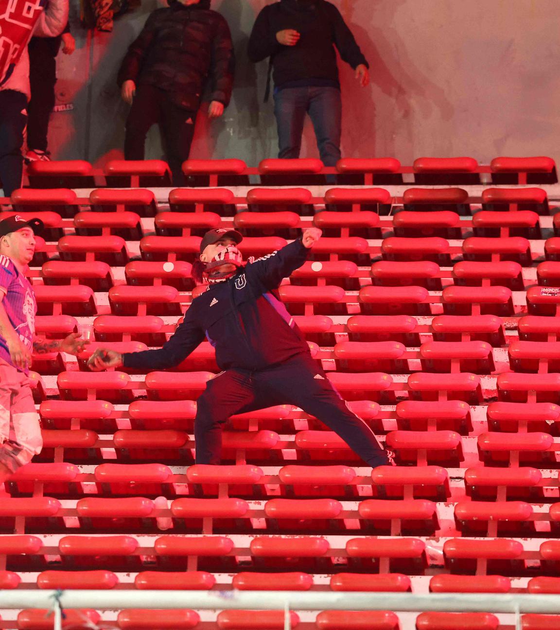 Ein Fan der Universidad de Chile bereitet sich darauf vor, während der Unterbrechung des Achtelfinal-Rückspiels der Copa Sudamericana zwischen Argentiniens Independiente und Chiles Universidad de Chile im Stadion Libertadores de America in Avellaneda, Provinz Buenos Aires, Argentinien, am 20. 8. 2025 einen Stein zu werfen. 