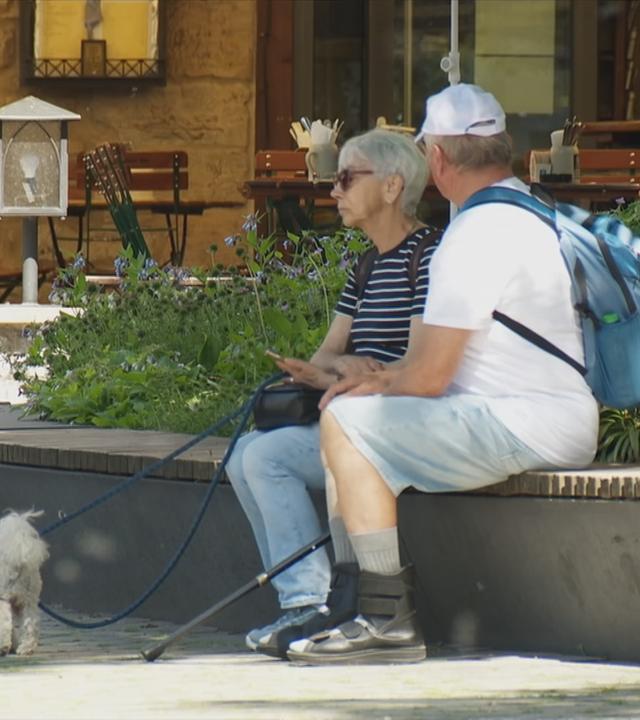 Zwei Senioren sitzen in der Stadt.