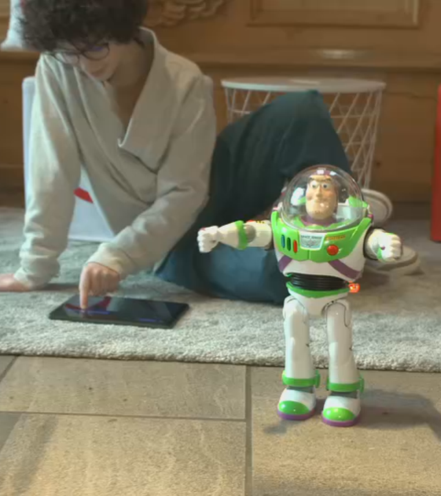 Ein Junge mit einem Tablet und eine Buzz Lightyear-Figur.