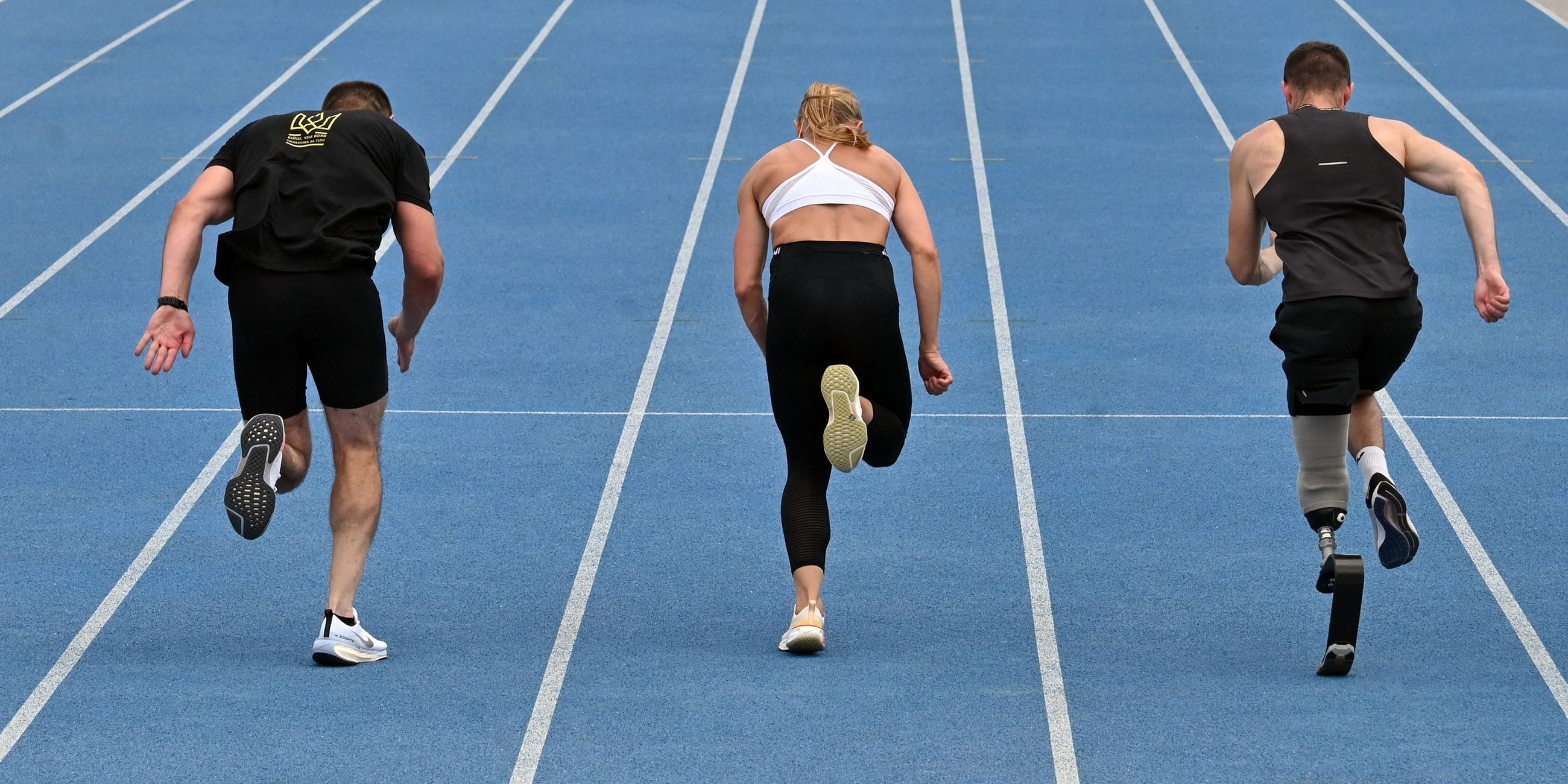 Es sind drei Sprinter von hinten zu sehen wie sie trainieren.