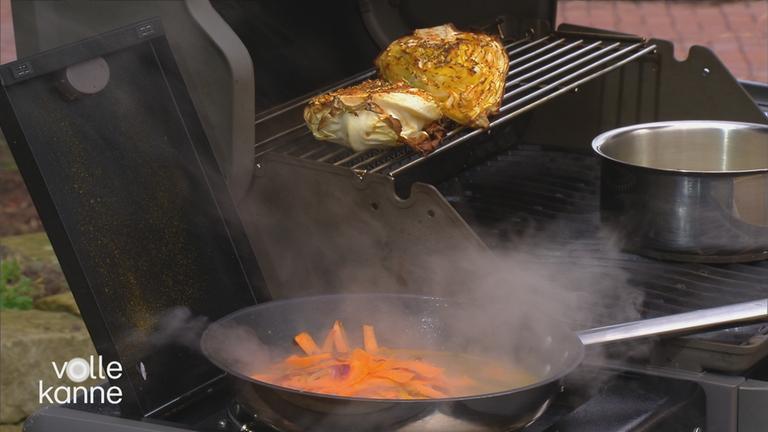 Grillgemüse auf einem Grill und Möhren in einer Pfanne.