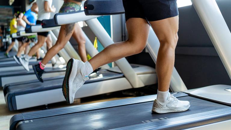 Männer und Frauen auf dem Laufband in einem Fitnessstudio