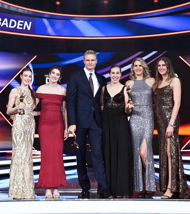 Baden-Württemberg, Baden-Baden: Die Sportgymnastin Darja Varfolomeev (l), der Ruderer Oliver Zeidler (3.v.l) und die 3x3-Basketballerinnen Elisa Mevius (2.v.l), Svenja Brunckhorst (M-r), Sonja Greinacher und Marie Reichert stehen während der Gala für die Wahl «Sportler des Jahres» im Kurhaus mit ihren Siegertrophäen auf der Bühne. 