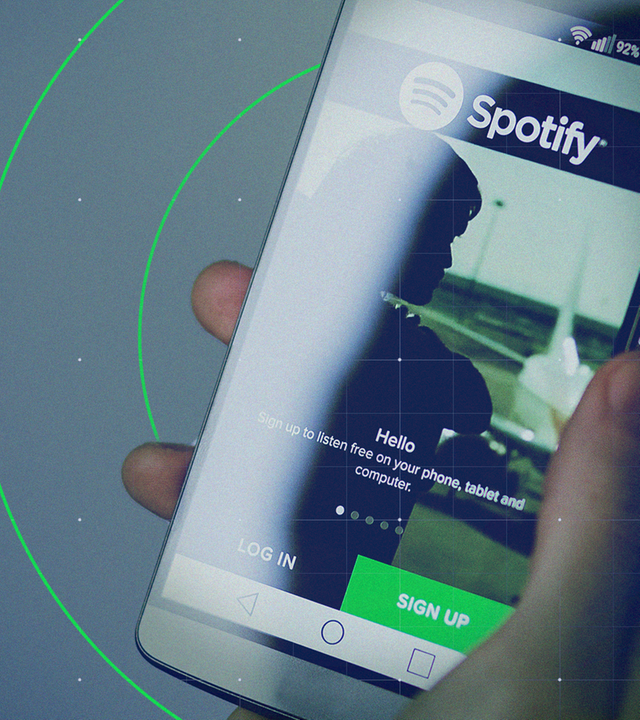 Hand hält Hand, das Spotify zeigt