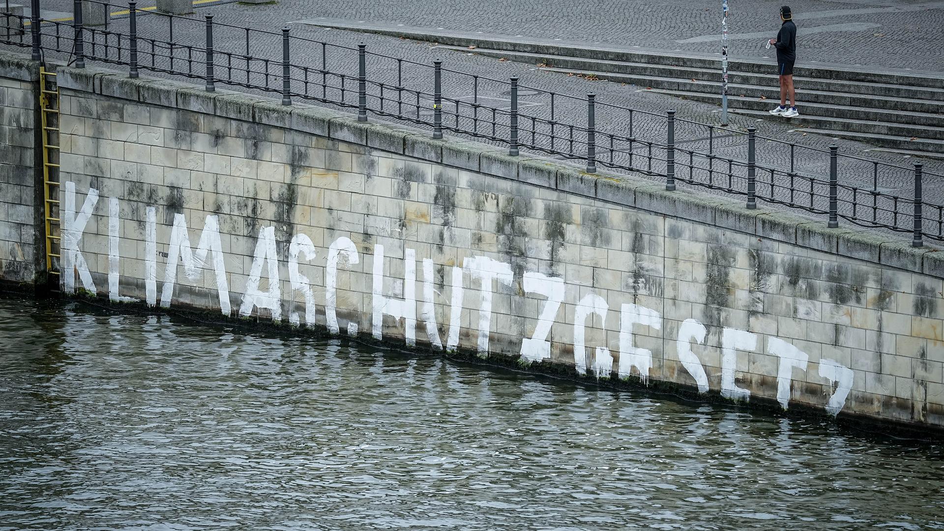 Das Wort "Klimaschutzgesetz" geht am Ufer der Spree im Regierungsviertel unter
