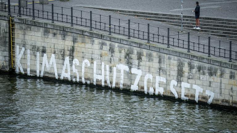 Das Wort "Klimaschutzgesetz" geht am Ufer der Spree im Regierungsviertel unter