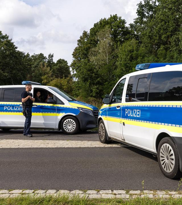 Brandenburg, Turnow-Preilack: Polizeieinsatzkräfte sperren die Straße zum Umspannwerk ab.